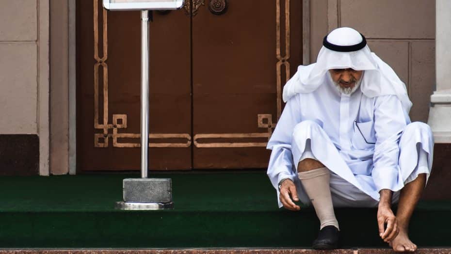 Mosque-goer removing his shoes at Jumeirah Mosque
