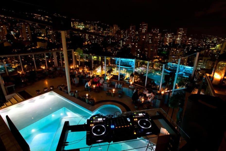 El Hotel Charlee es uno de los mejores hoteles de El Poblado (Medellín) porque tiene una discotecta en la azotea con mesas junto a la piscina