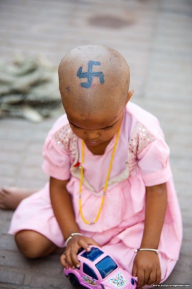 Niña hindú con una esvástica pintada en la cabeza